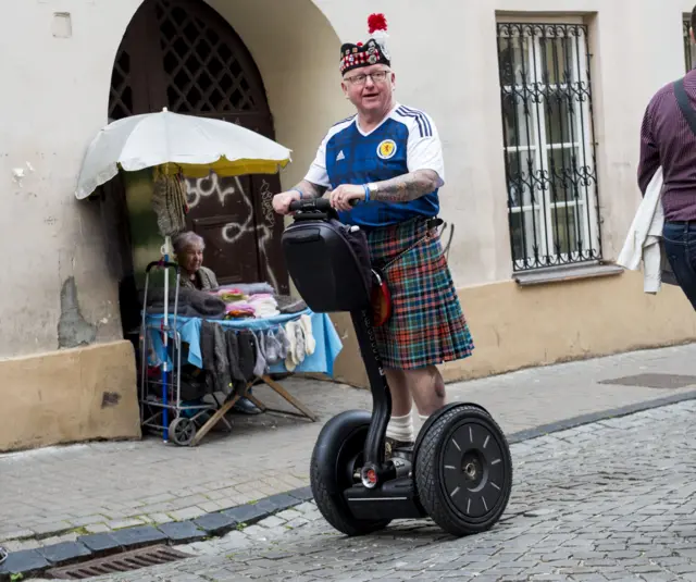 A Scotland supporter takes the weight off his feet for some sight-seeing in Vilnius