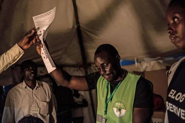 Man holding up ballot paper