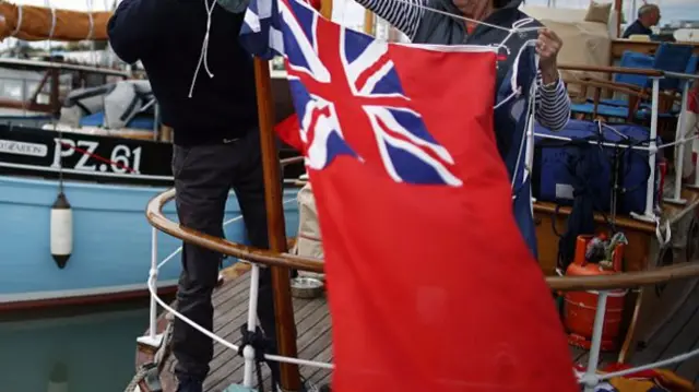 Red Ensign flag being tied on a ship