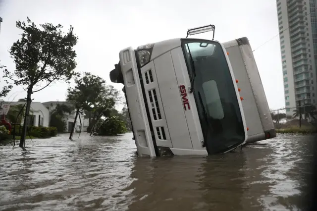 An overturned vehicle on a flooded street in Miami