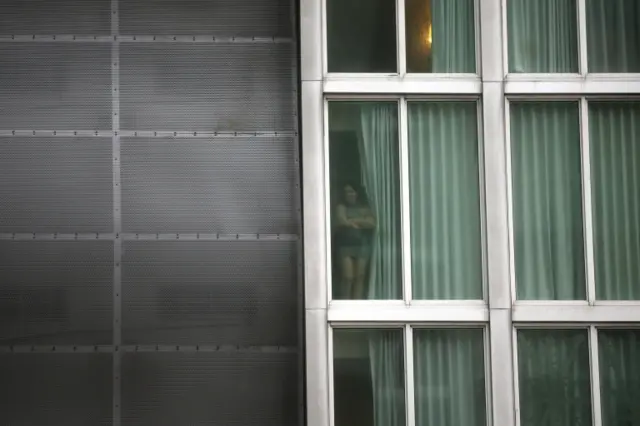 A woman stands by a hotel window as Hurricane Irma arrives at south Florida, in downtown Miami, Florida, U.S