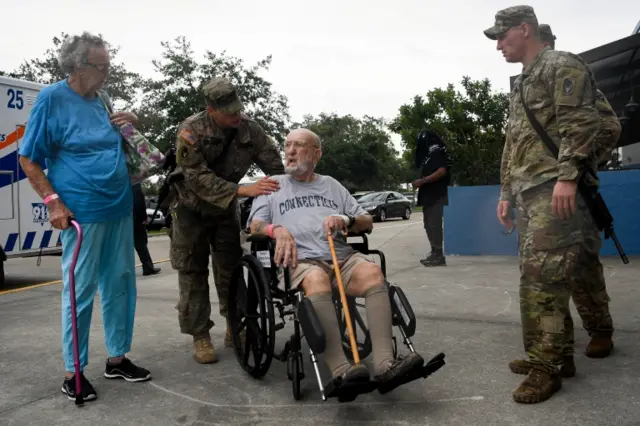 Members of the National Guard help an elderly couple in Estero, Florida.