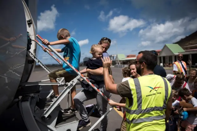 People board a plane in St Martin, where evacuations are under way in the wake of Hurricane Irma.