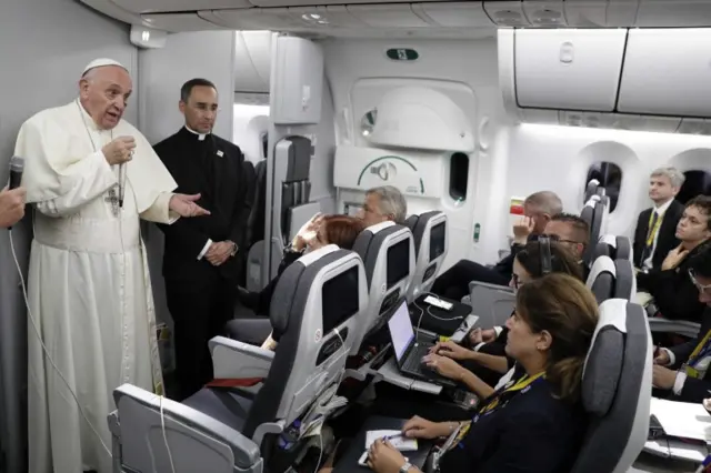 Pope Francis (left) talks to journalists during a press conference he held on board of his flight to Rome at the end of a five-day visit to Colombia