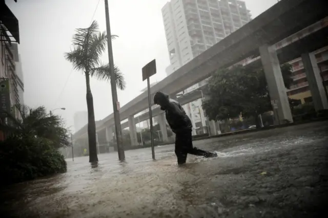 A local resident walks across a flooded street in downtown Miami as Hurricane Irma arrives at south Florida on 10 September, 2017