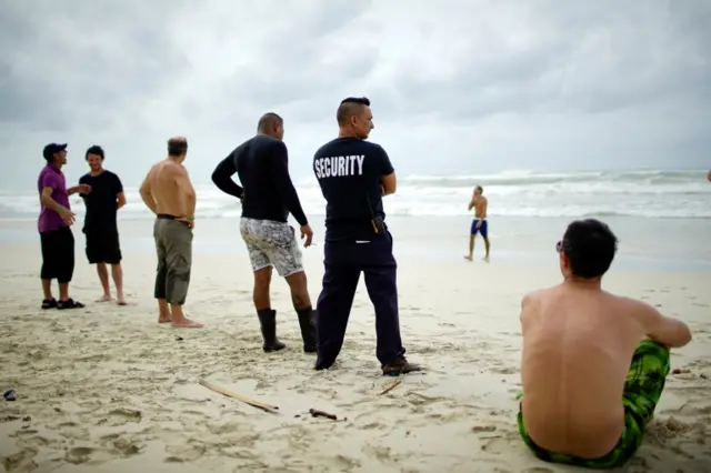 Tourists and a security agent are seen on a beach a day after the passage of Hurricane Irma in Varadero, Cuba