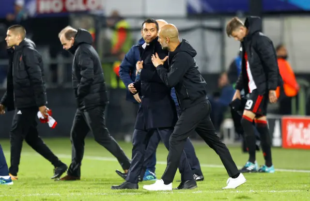 Manchester City manager Pep Guardiola with Feyenoord coach Giovanni van Bronckhorst