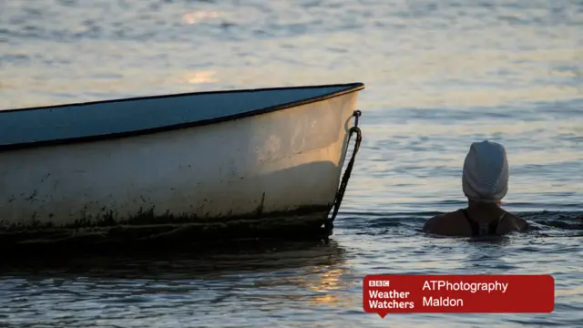 A swimmer by a moored boat