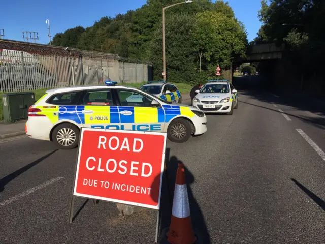 Road closed sign and police cars