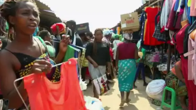 Women sell clothes in an open-air market