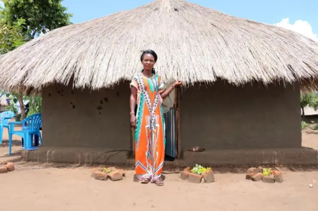 Christine stands in front of her home