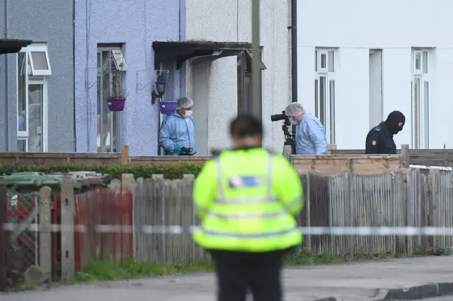 Investigators search a house in Sunbury-on-Thames