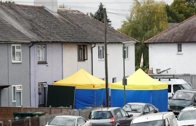 Forensic teams have placed tents at the front and back of the property