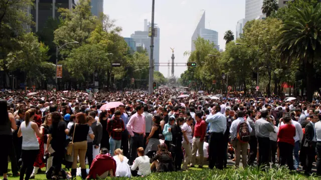 People crowd Reforma avenue after a strong earthquake in Mexico City on September 19, 2017