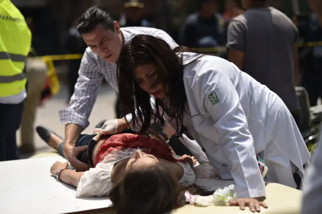 An injured woman is helped after a powerful quake in Mexico City on 19 September