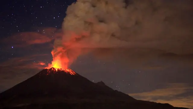 Image shows the Popocatepetl volcano erupting at night