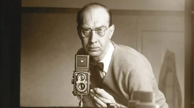 Philip Larkin with a camera pointed at a mirror, taking a picture of himself.