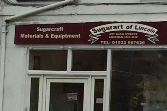 Image of the sign above the shop. Equipment is spelled 'Equiptment'