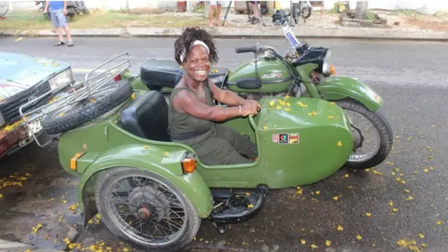 Mary Russell sitting in the pillion seat of a Vietnam motorbike