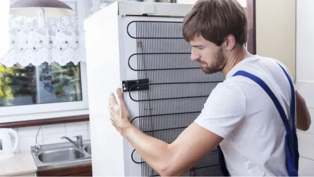 workman removes fridge