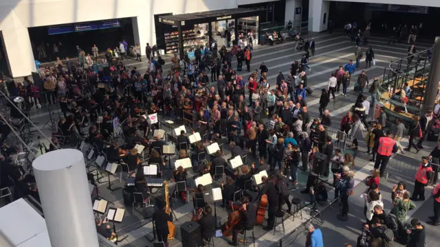 City of Birmingham Symphony Orchestra is performing on the concourse of New Street station.