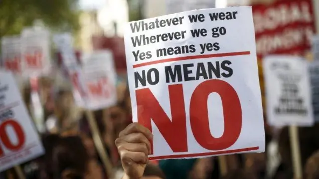 A sign reads "whatever we wear, wherever we go, yes means yes, no means no"