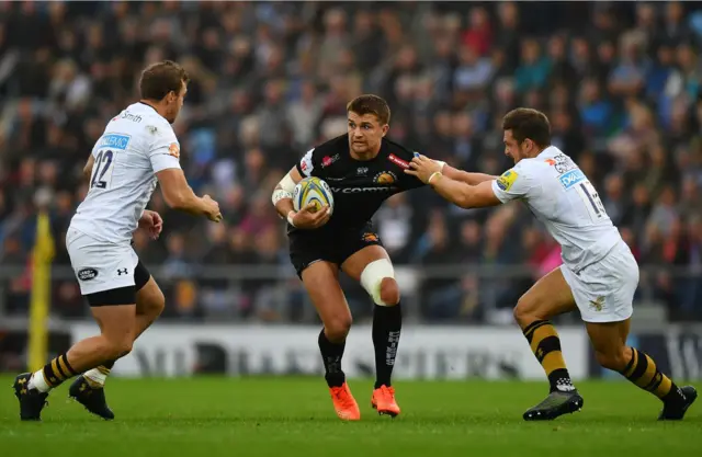 Henry Slade of Exeter Chiefs holds off Jimmy Gopperth of Wasps