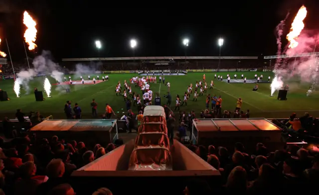 Teams walk onto the field