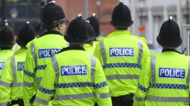 Rear view of police officers in reflective jackets