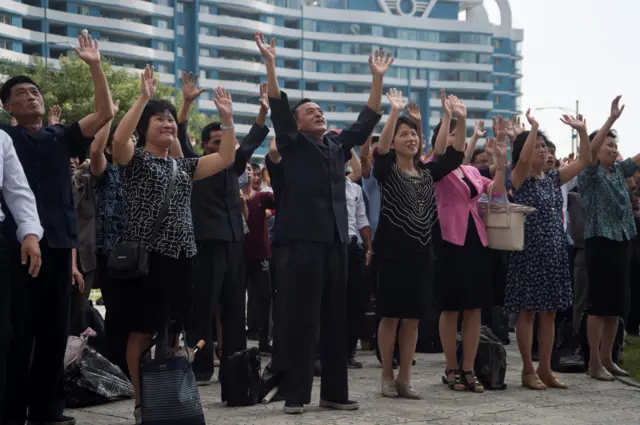 People waving their arms in celebration