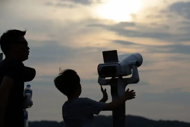 A South Korean boy uses binoculars to look over the North Korea at the Imjingak observation post in Paju