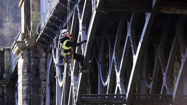 An engineer abseiling down the bridge to perform a condition check