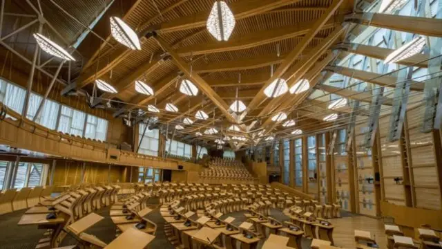 There are bright lights on the ceiling of the Holyrood chamber as well as on the benches below