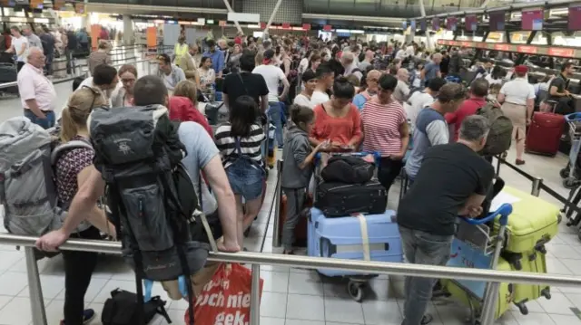 Passengers queue for check-in