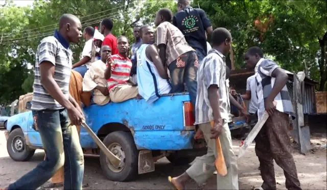 Machete and axe wielding neighbourhood vigilantes hop into a pick-up on July 19, 2013 for an operation to hunt down Boko Haram Islamists in Maiduguri,