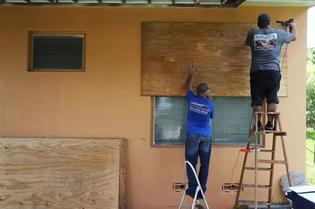 men boarding up windows