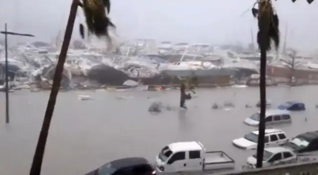 Submerged vehicles, boats and floating debris in the flooded harbour on the French island territory of Saint-Martin