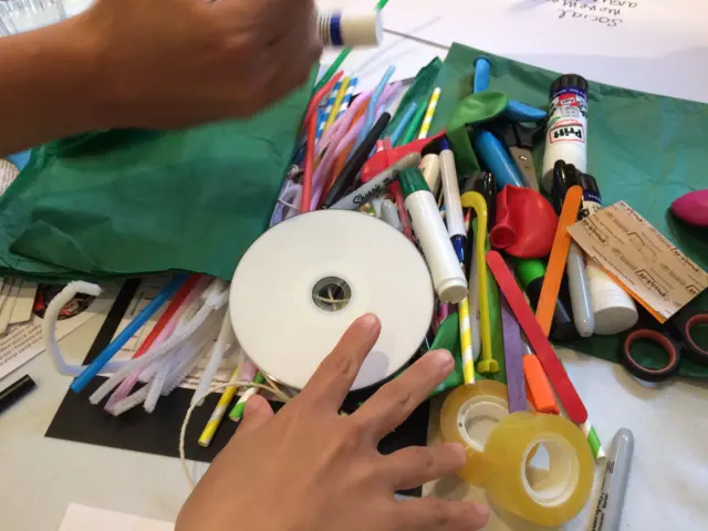 Pens, tape, scissors and a compact disc on a table