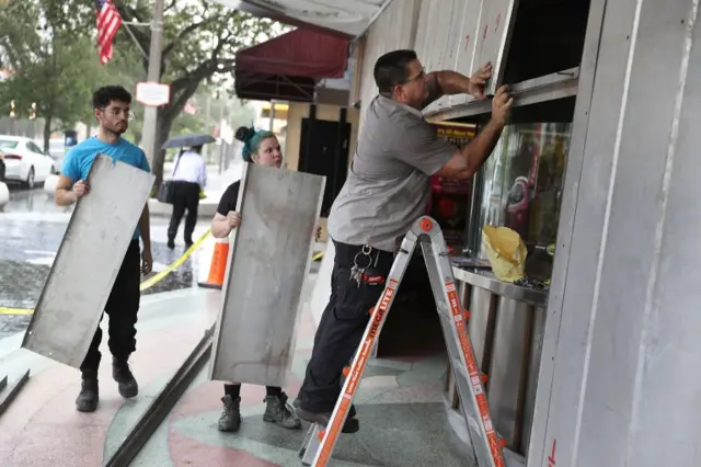 People board up a building as they prepare for the storm in Miami, Florida