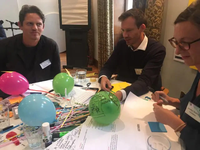 People sitting around table with balloons