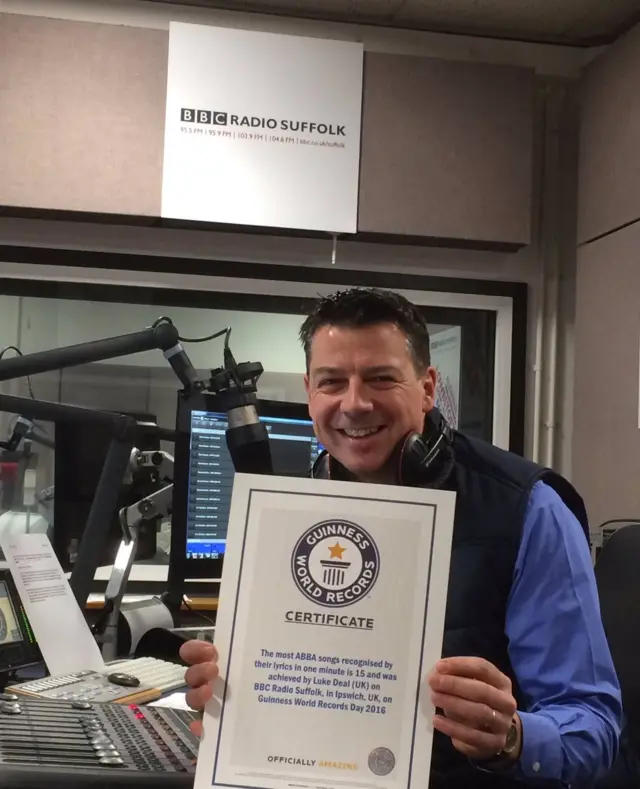 Luke Deal in studio, with his certificate