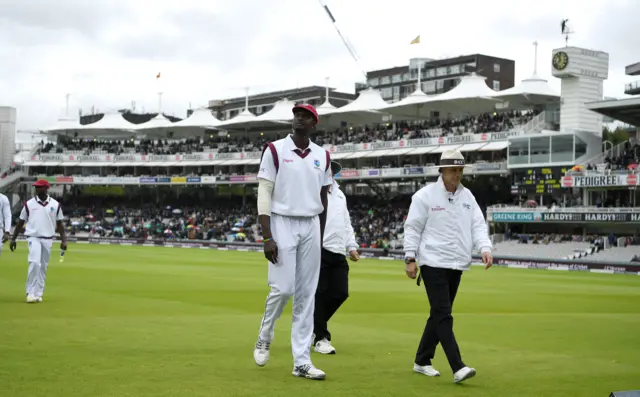 England and West Indies players leave the field due to rain