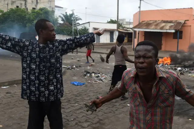 Protesters shout with rocks in their hands