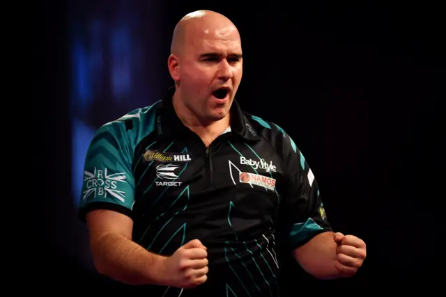 Rob Cross celebrates winning the first set