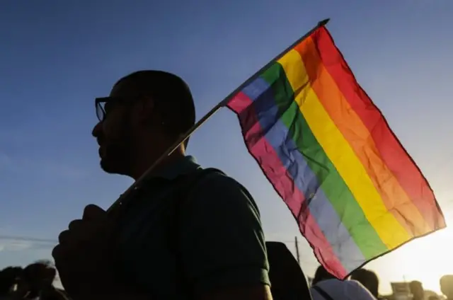 Person holding rainbow flag