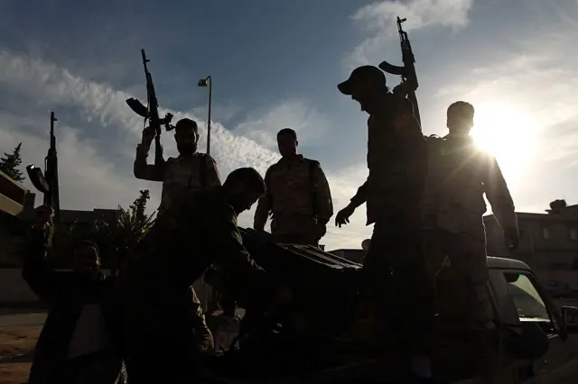 Members of a brigade headed by field commander Salah Bogheib and loyal to Khalifa Haftar -a retired general and former chief of staff for Moamer Kadhafi- hold up their guns as they fight alongside Libyan army troops against Islamist gunmen in the eastern Libyan city of Benghazi on December 17, 2014.