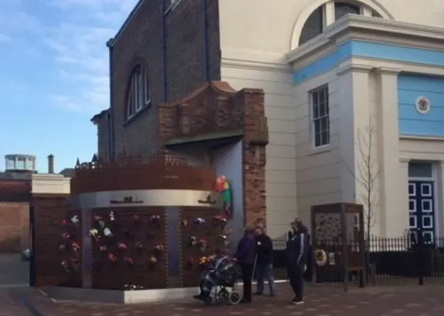 People stood looking at the Fisherman's memorial.