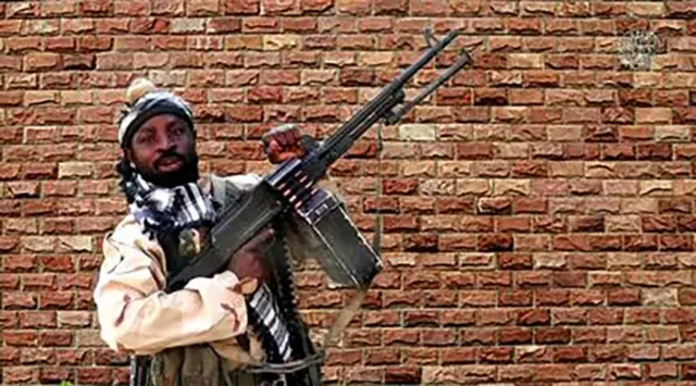 In this video grab made on January 15, 2018 from a video released the same day by Islamist militants group Boko Haram shows Boko Haram factional leader Abubakar Shekau firing a heavy machine gun. T