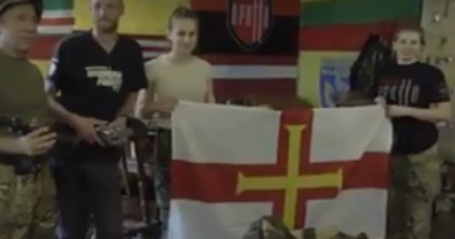 A Guernsey flag is unfurled