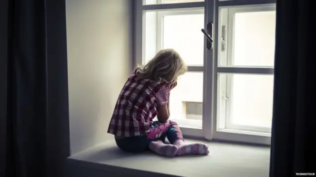 Generic photograph of child looking out a window